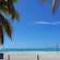Three beach chairs sit next to a volleyball net on an empty beach